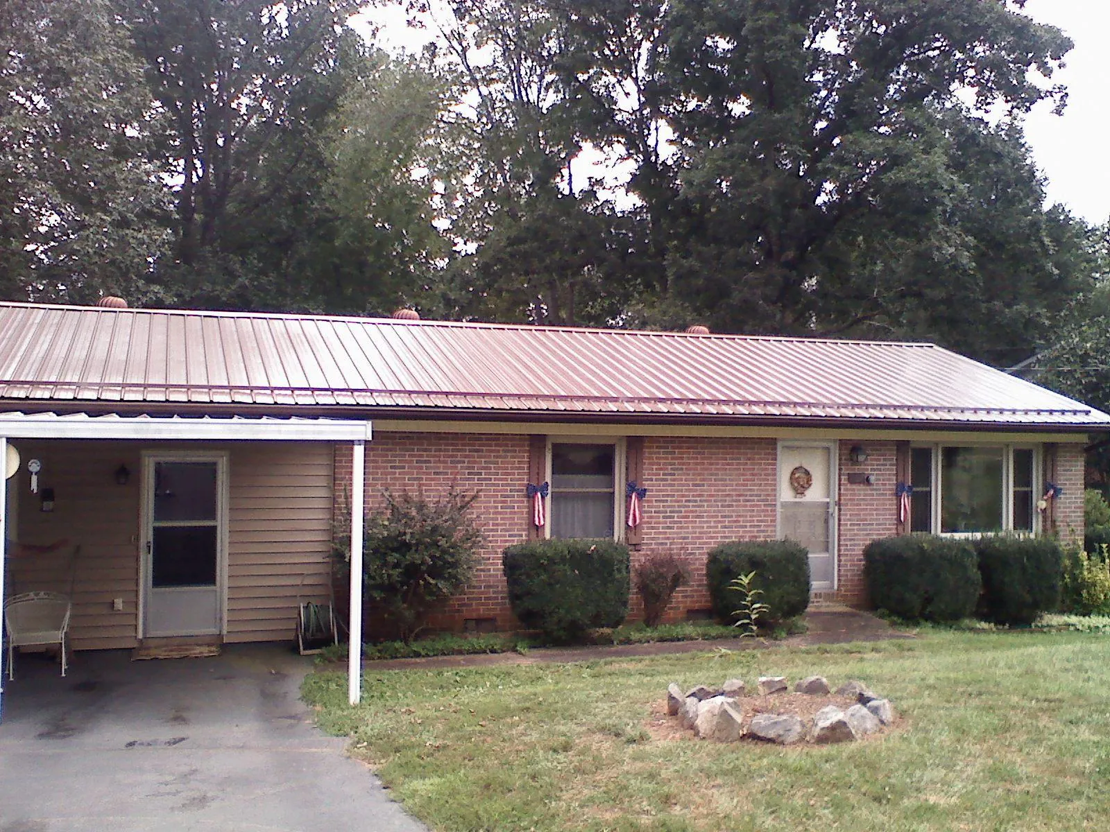 Bronze metal roof and carport on a brick ranch home — Roof Repair work by our crew in Ballantine